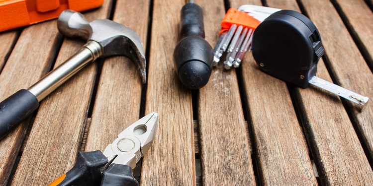 Assortment of tools, including a hammer, pliers, tape measure, and drill bits